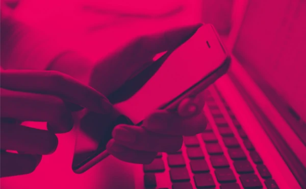 Pessoa usando celular e notebook ilustrando a execução do Serviço de Manutenção de Sites WordPress